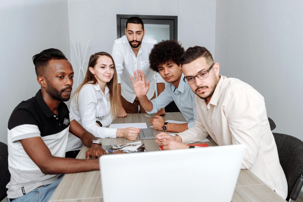 Team of professionals collaborating around a laptop during a business meeting in a modern office.